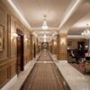 Installed Lighting Cove Molding for Indirect Lighting creating soft perimeter ceiling illumination in an elegant hotel-style corridor.