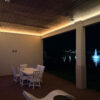 Installed Asheville Molding for Indirect Lighting creating soft perimeter ceiling illumination on a covered outdoor patio at night.